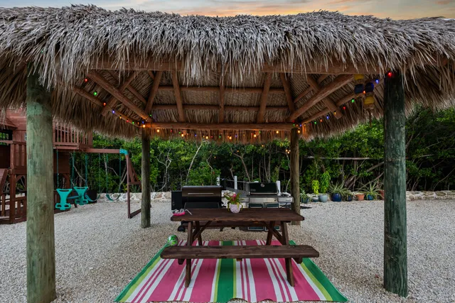 a view of a patio with table and chairs with wooden floor and fence