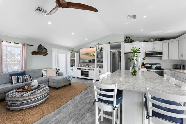 a living room with stainless steel appliances kitchen island granite countertop furniture and a view of kitchen