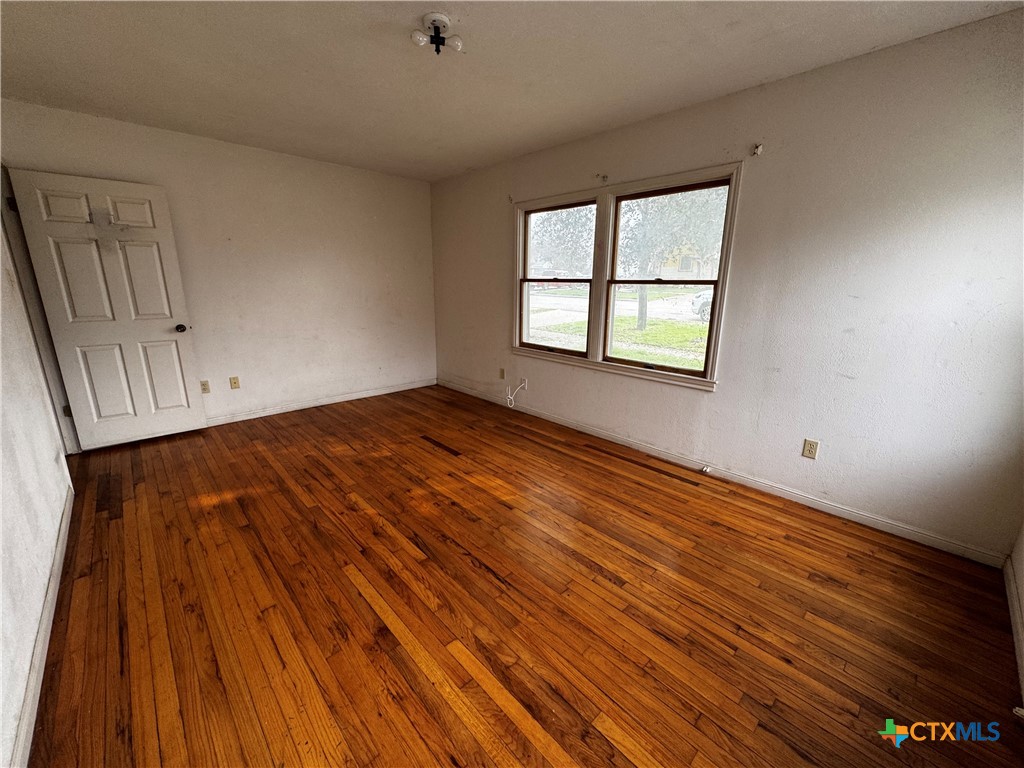 1010 South 17th Street Temple, TX 76504 - Photo 17 of 30 a view of an empty room with wooden floor and a window