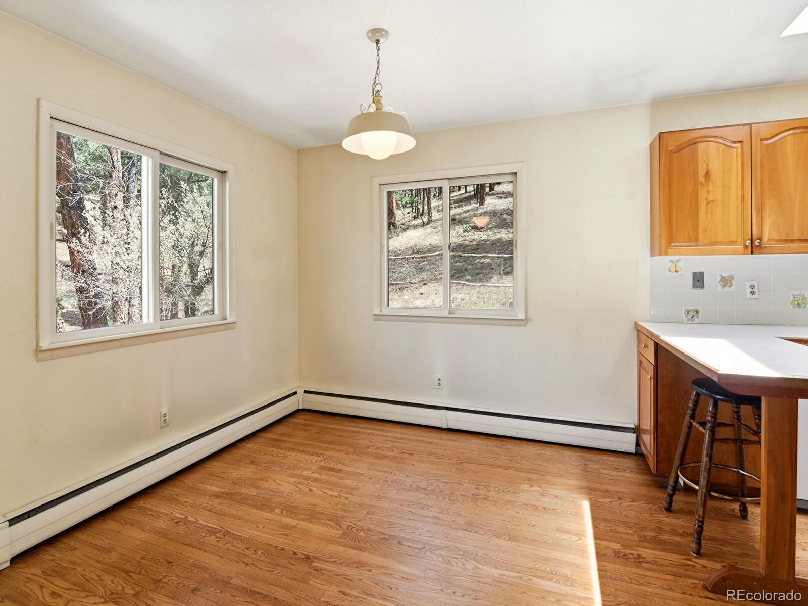 2830 Kerr Gulch Road Evergreen, CO 80439 - Photo 17 of 48 a view of an empty room with window and wooden floor