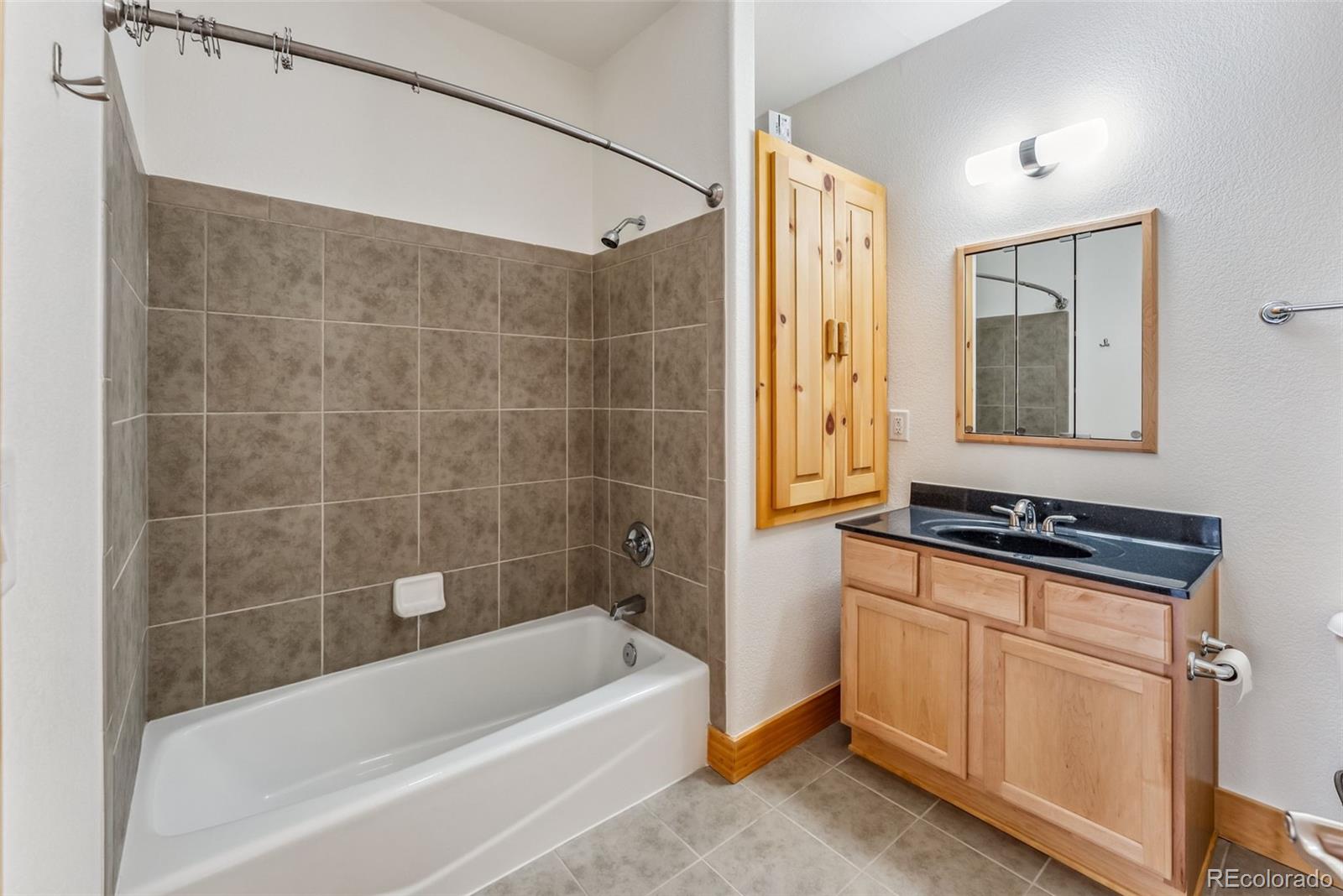 135 Main Street, Unit 214 Dillon, CO 80435 - Photo 24 of 42 a bathroom with a tub a sink a mirror and a shower