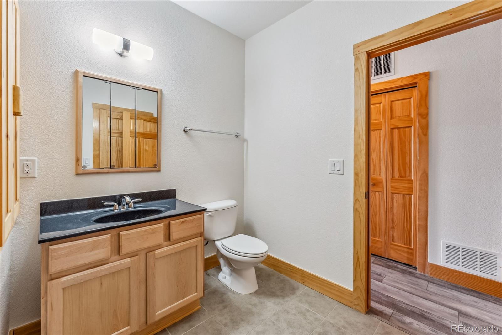 135 Main Street, Unit 214 Dillon, CO 80435 - Photo 25 of 42 a bath room with a sink a toilet and a mirror