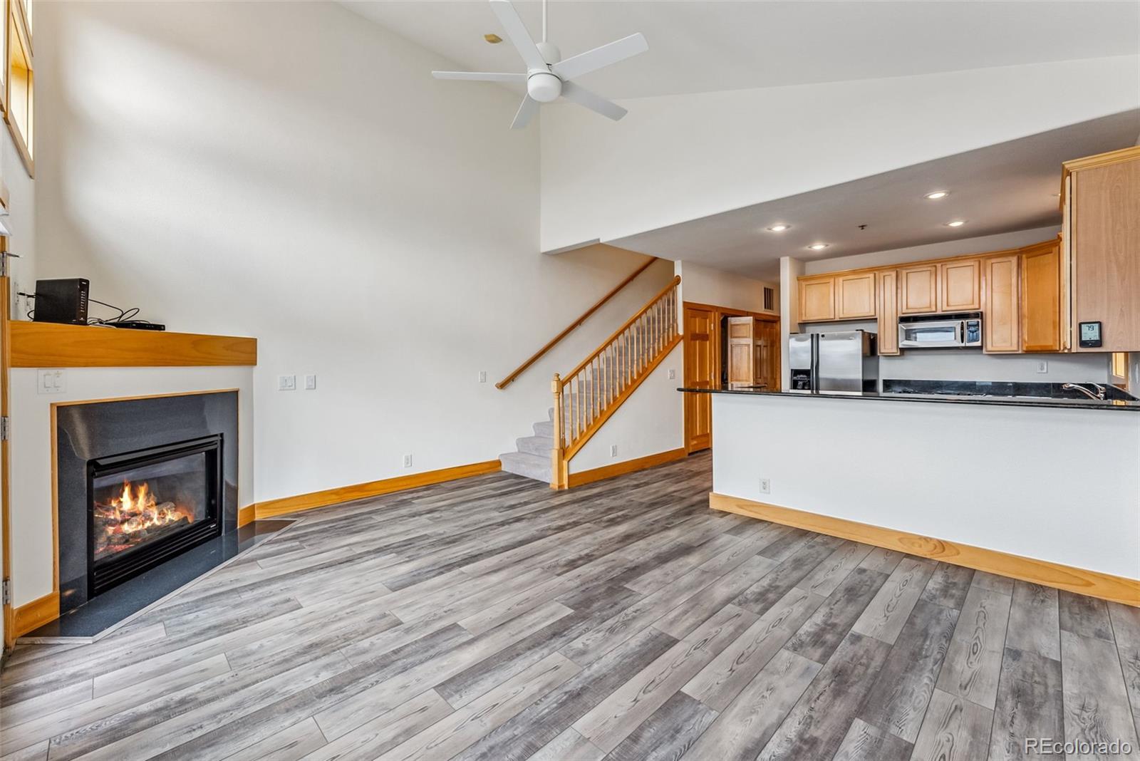 135 Main Street, Unit 214 Dillon, CO 80435 - Photo 5 of 42 a living room with stainless steel appliances kitchen island a fireplace wooden floor and a window