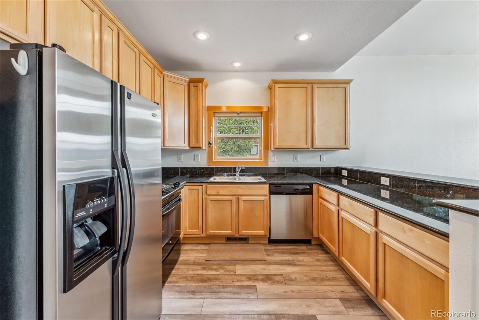 135 Main Street, Unit 214 Dillon, CO 80435 - Photo 9 of 42 a kitchen with stainless steel appliances granite countertop a refrigerator a sink and a stove