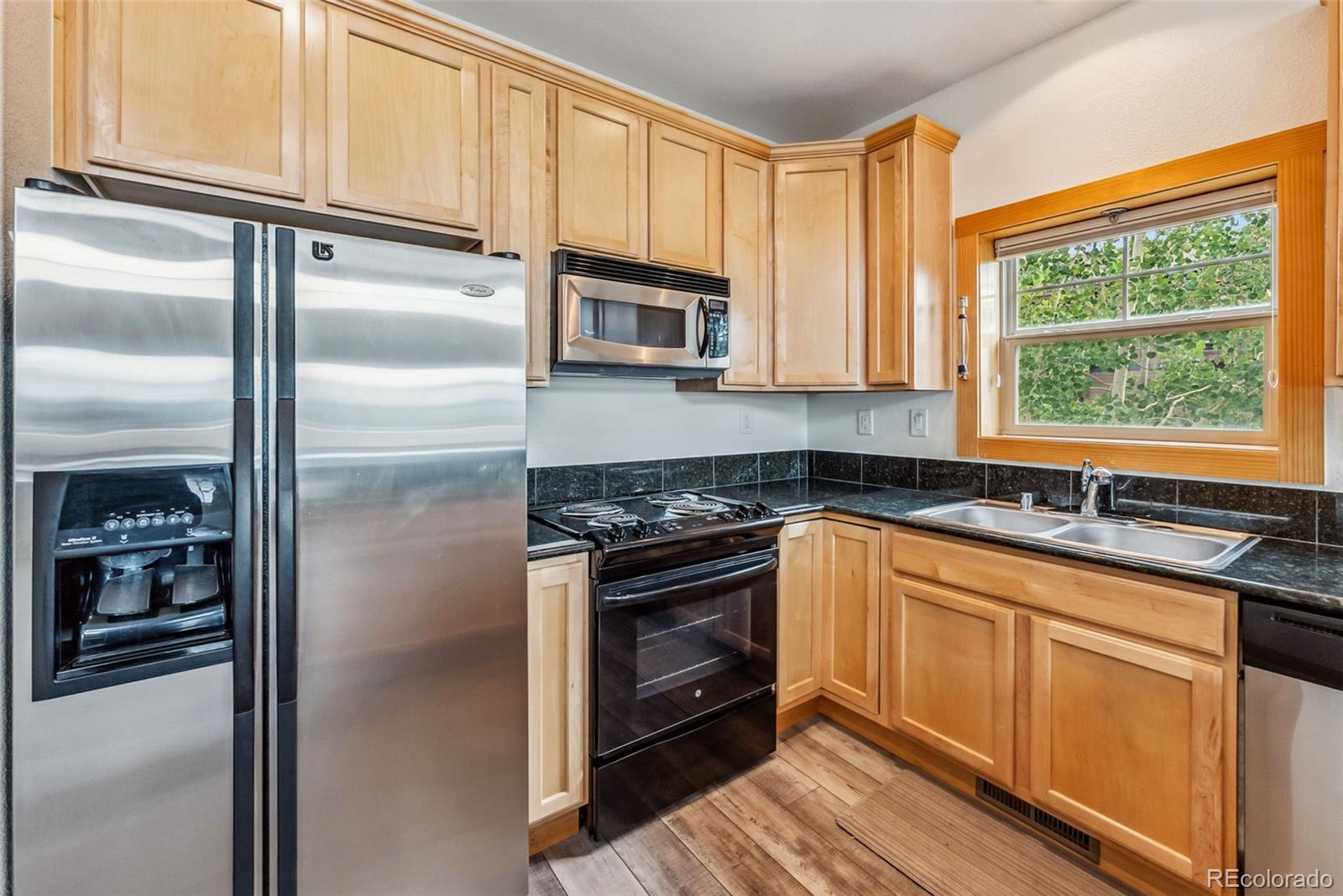 135 Main Street, Unit 214 Dillon, CO 80435 - Photo 10 of 42 a kitchen with stainless steel appliances granite countertop a refrigerator a sink a stove and cabinets