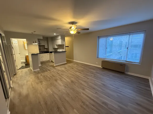 a view of a kitchen with wooden floor and a kitchen space with a sink