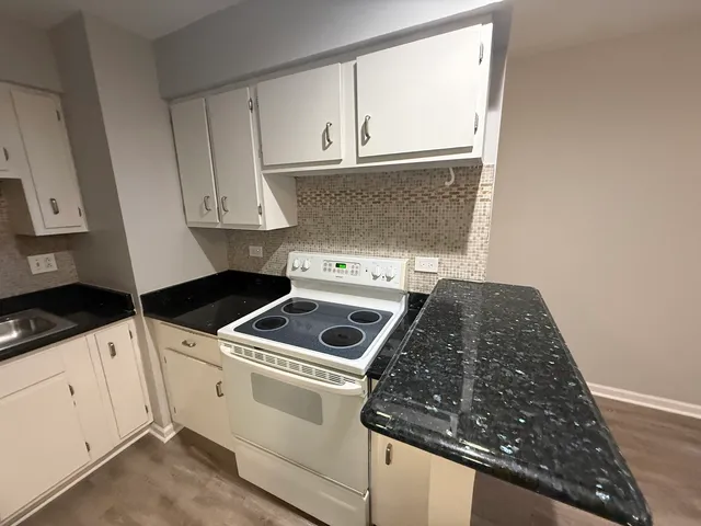 a kitchen with white cabinets and white appliances