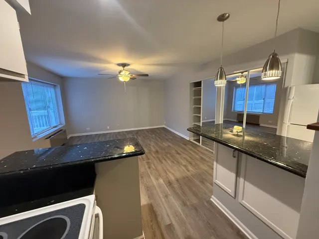 a kitchen with granite countertop a sink a counter space appliances and cabinets