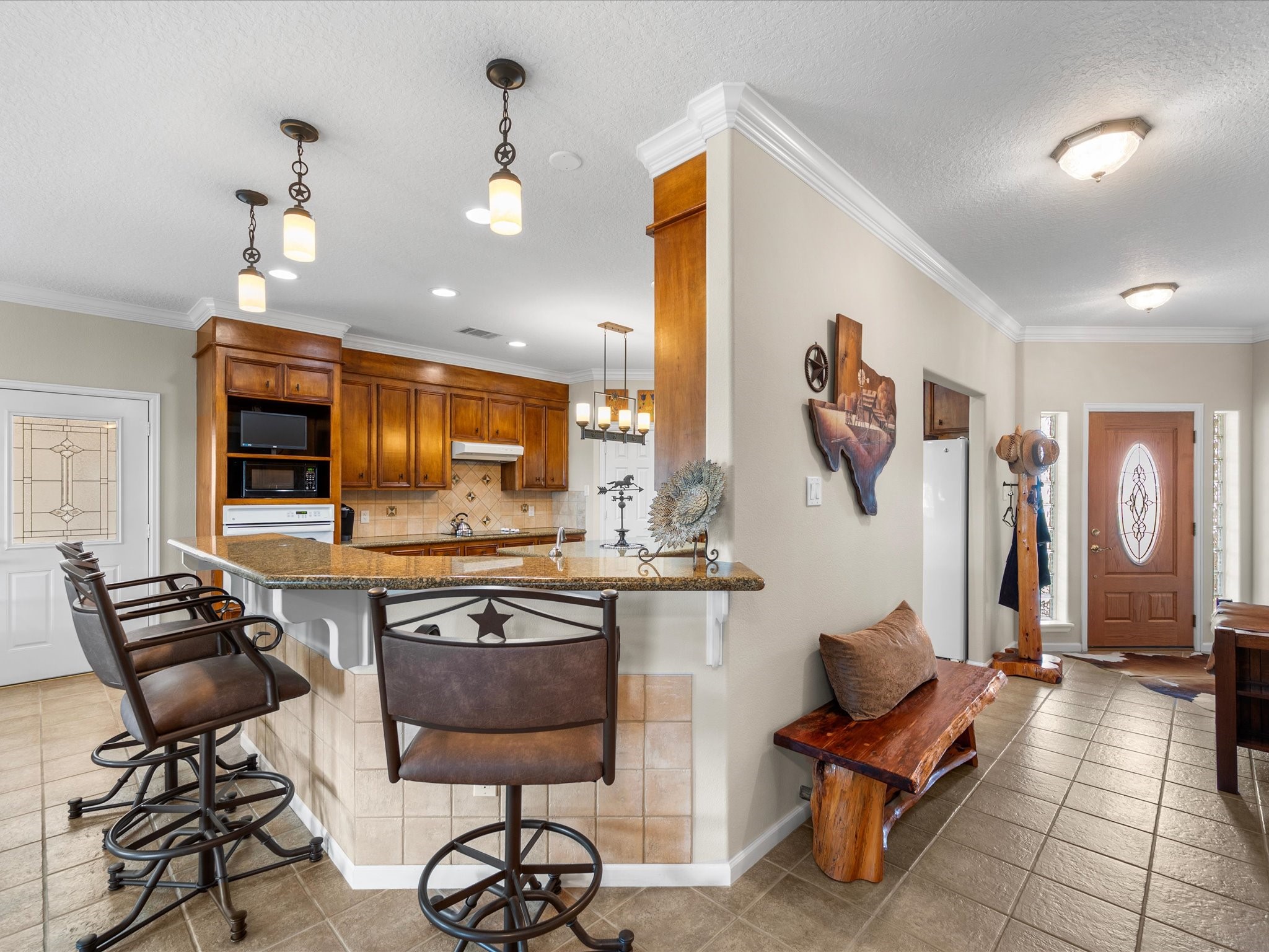 19929 Pierceall Road Hempstead, TX 77445 - Photo 15 of 50 The kitchen pairs gleaming granite counters with a convenient breakfast bar and beautiful lighting, creating a bright and welcoming space for gathering.