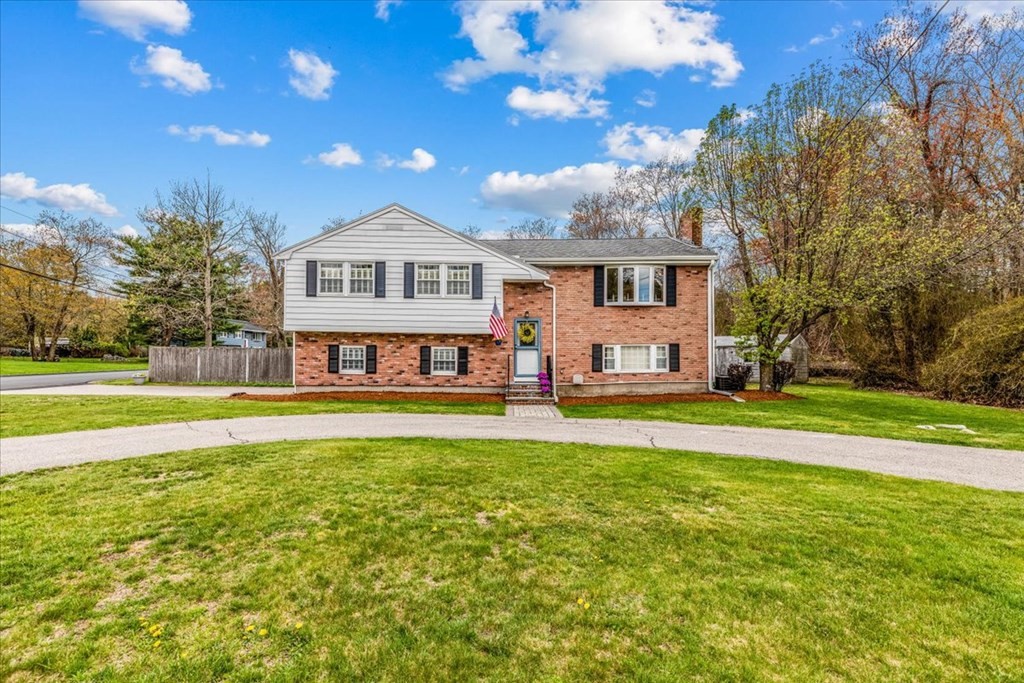 a view of a house with a big yard and large trees