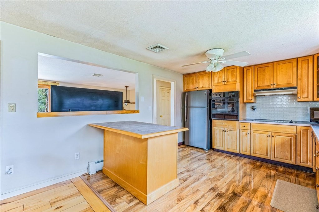 8 Stonewood Drive Canton, MA 02021 - Photo 10 of 29 a kitchen with stainless steel appliances a stove a refrigerator and wooden cabinets