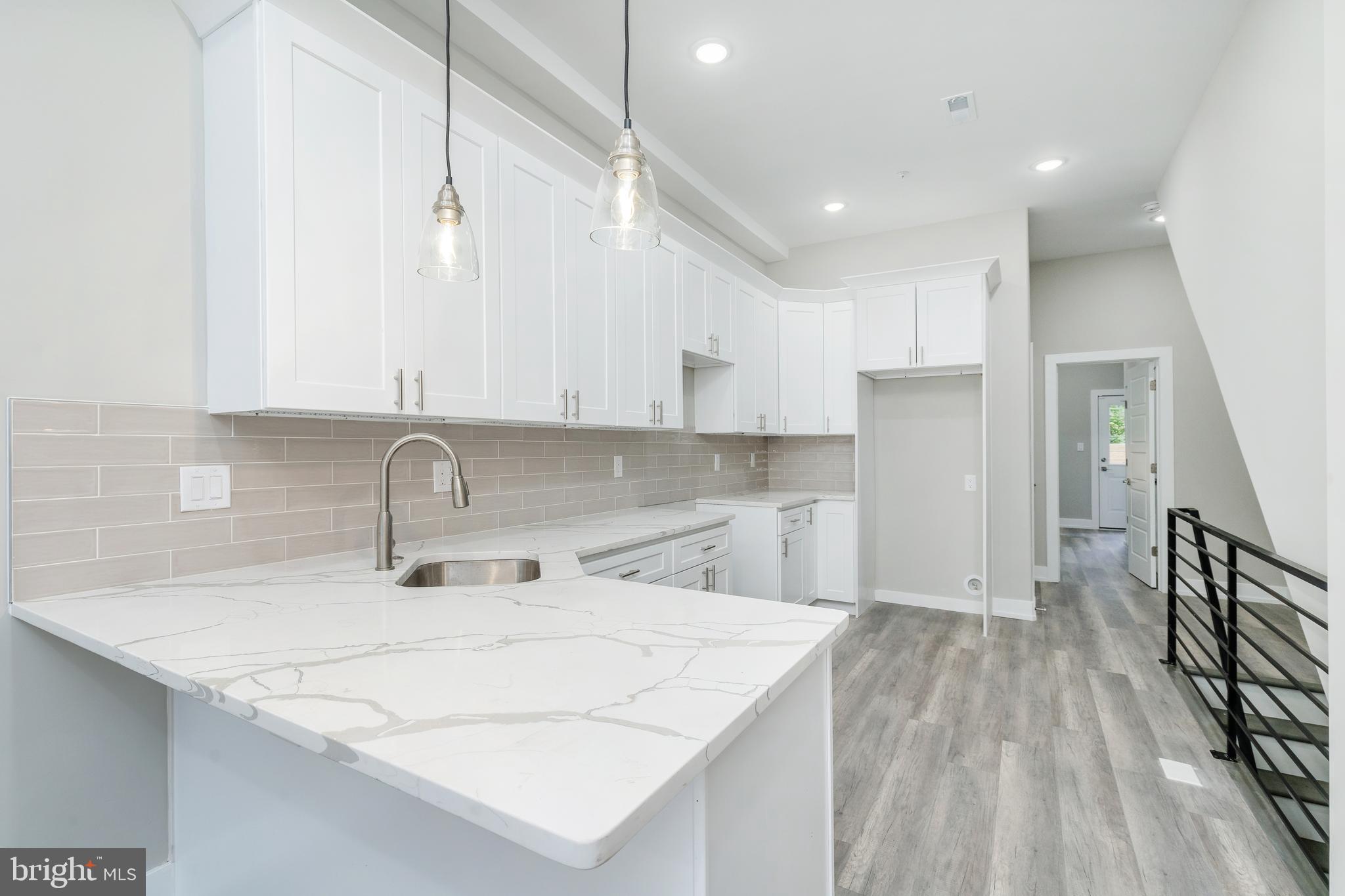 a kitchen with a sink a refrigerator and cabinets