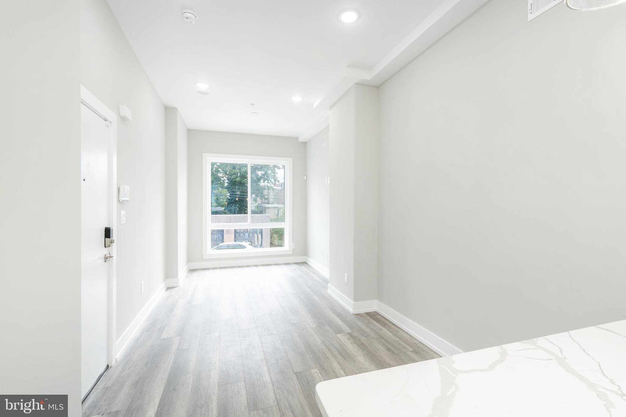 103 East Duval Street, Unit 1 Philadelphia, PA 19144 - Photo 8 of 32 a view of a livingroom with wooden floor and a window
