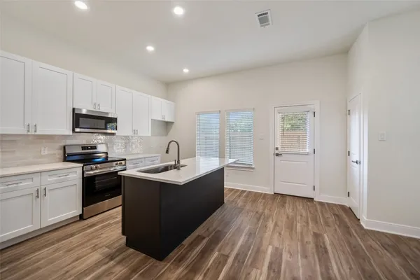 a kitchen with a sink window and cabinets
