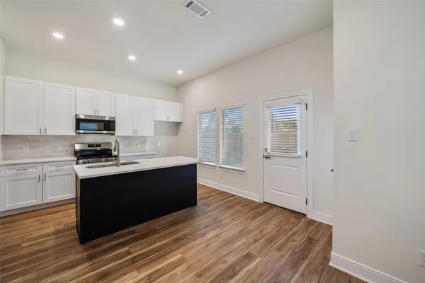 a large kitchen with stainless steel appliances granite countertop a stove a sink and a refrigerator