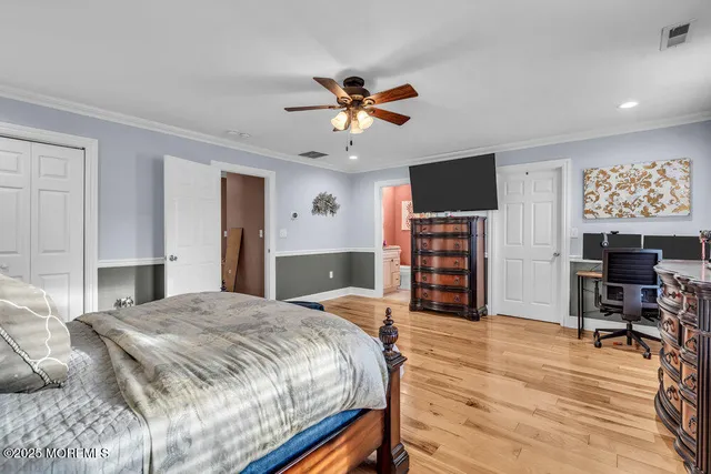 a spacious bedroom with a bed and a flat screen tv