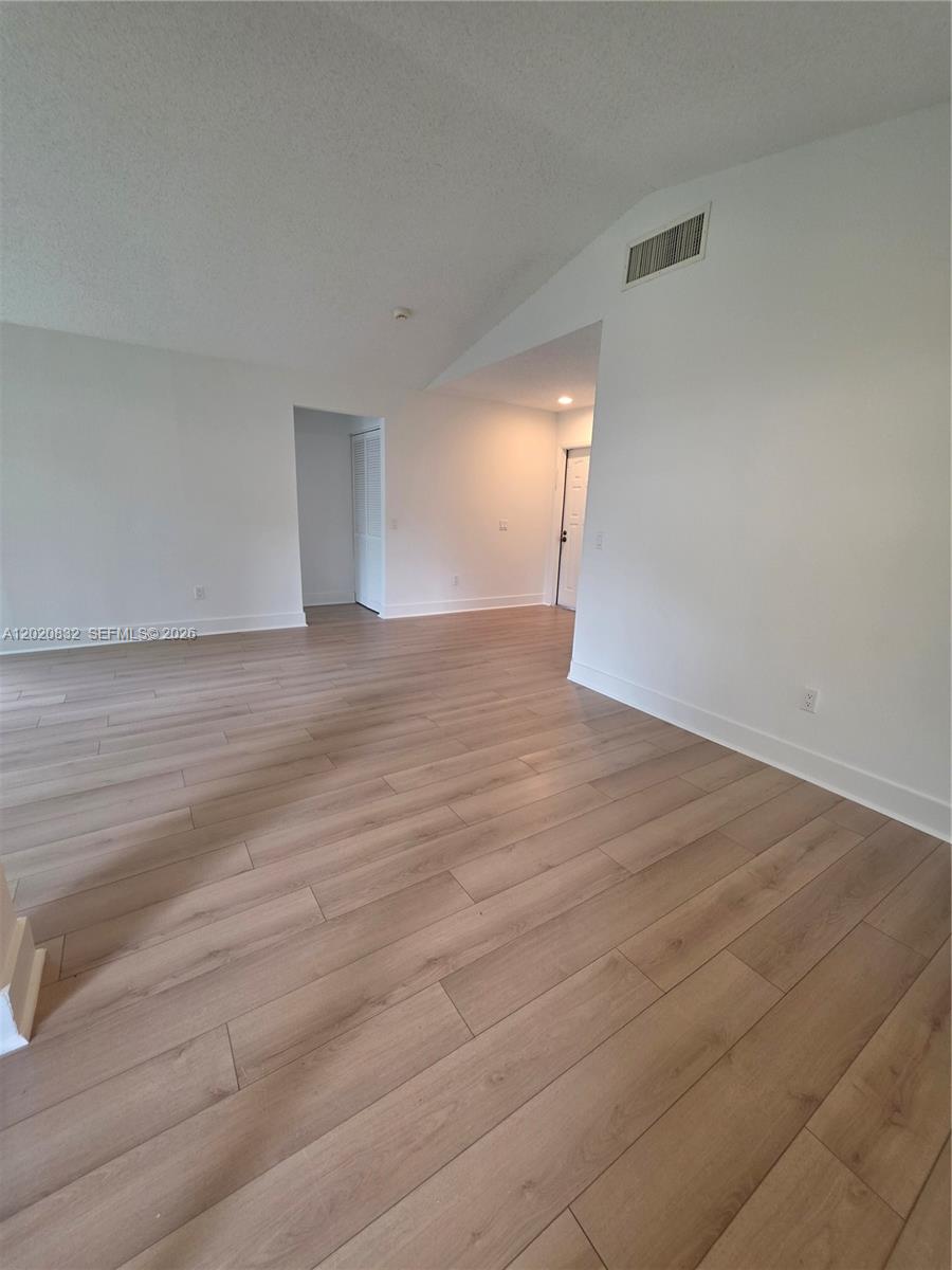 15240 Southwest 45th Terrace, Unit 54F Miami, FL 33185 - Photo 13 of 48 a view of empty room with wooden floor