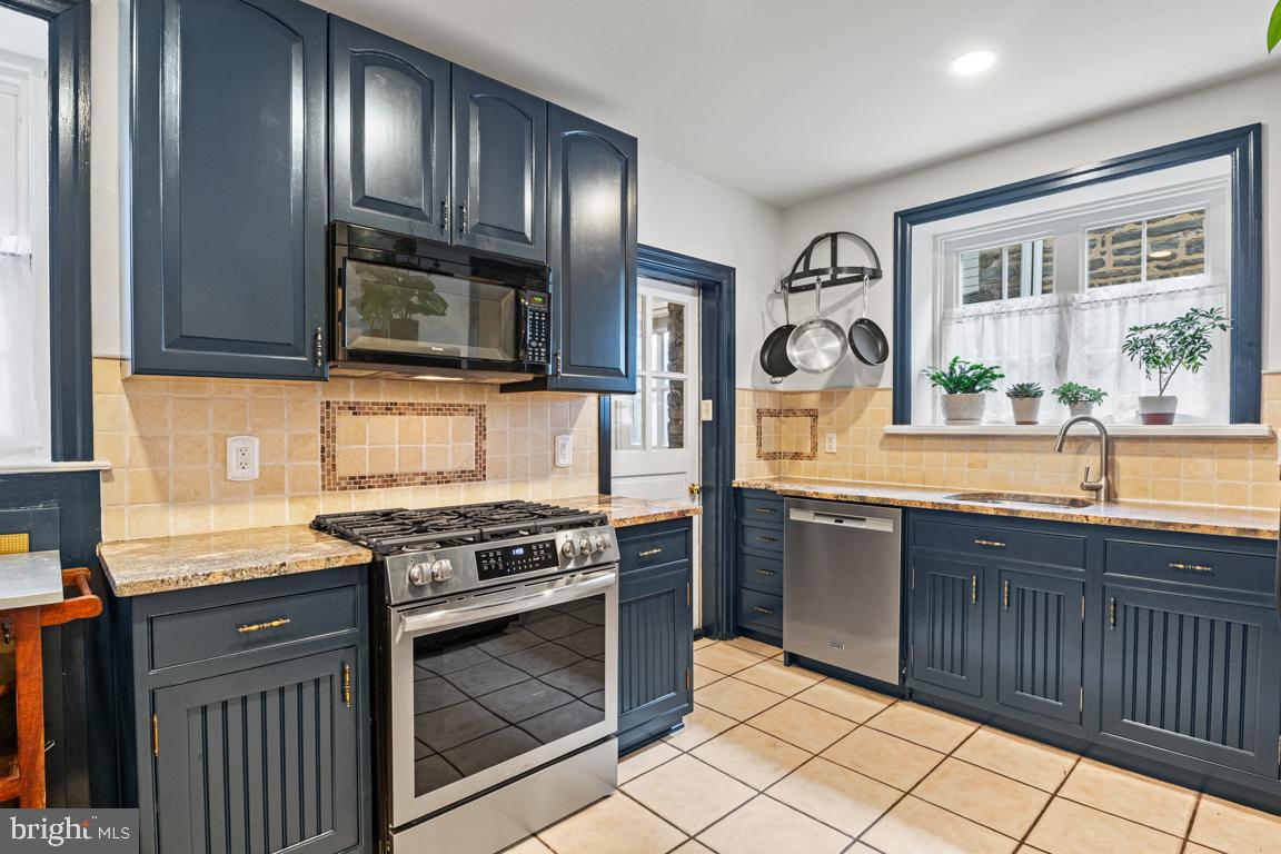 8023 Seminole Street Philadelphia, PA 19118 - Photo 14 of 42 a kitchen with stainless steel appliances granite countertop a stove and a sink