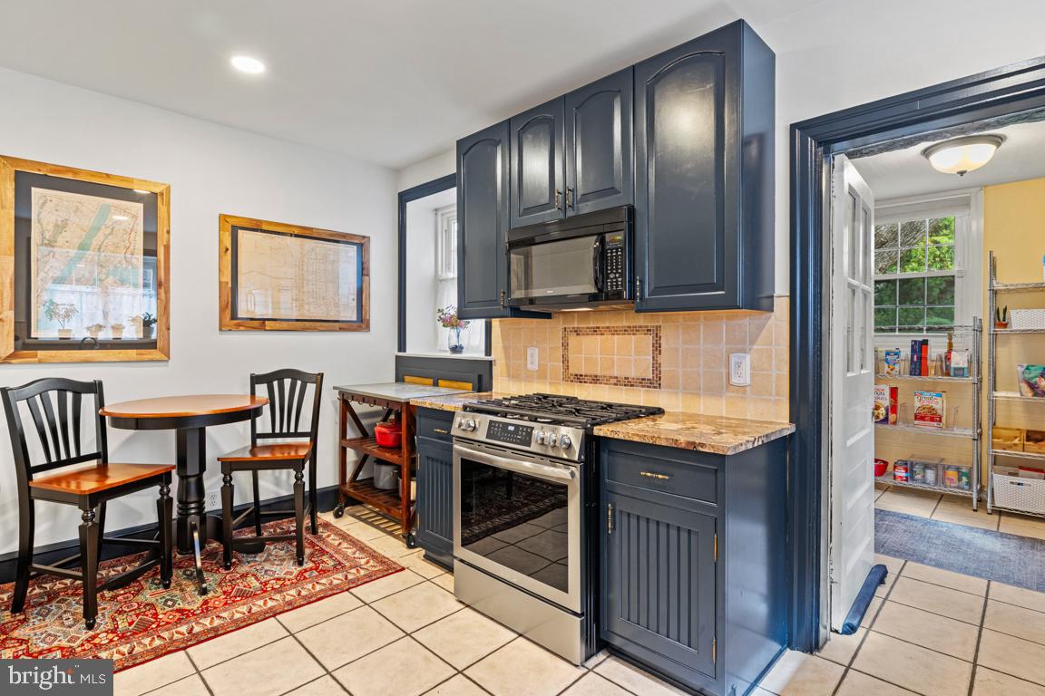 8023 Seminole Street Philadelphia, PA 19118 - Photo 16 of 42 a kitchen with stainless steel appliances granite countertop a stove top oven a sink and a chairs