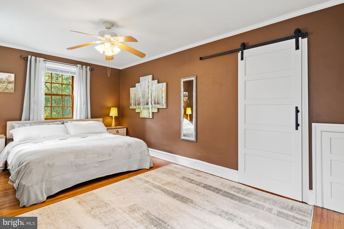 8023 Seminole Street Philadelphia, PA 19118 - Photo 22 of 42 a bedroom with a large bed and a chandelier
