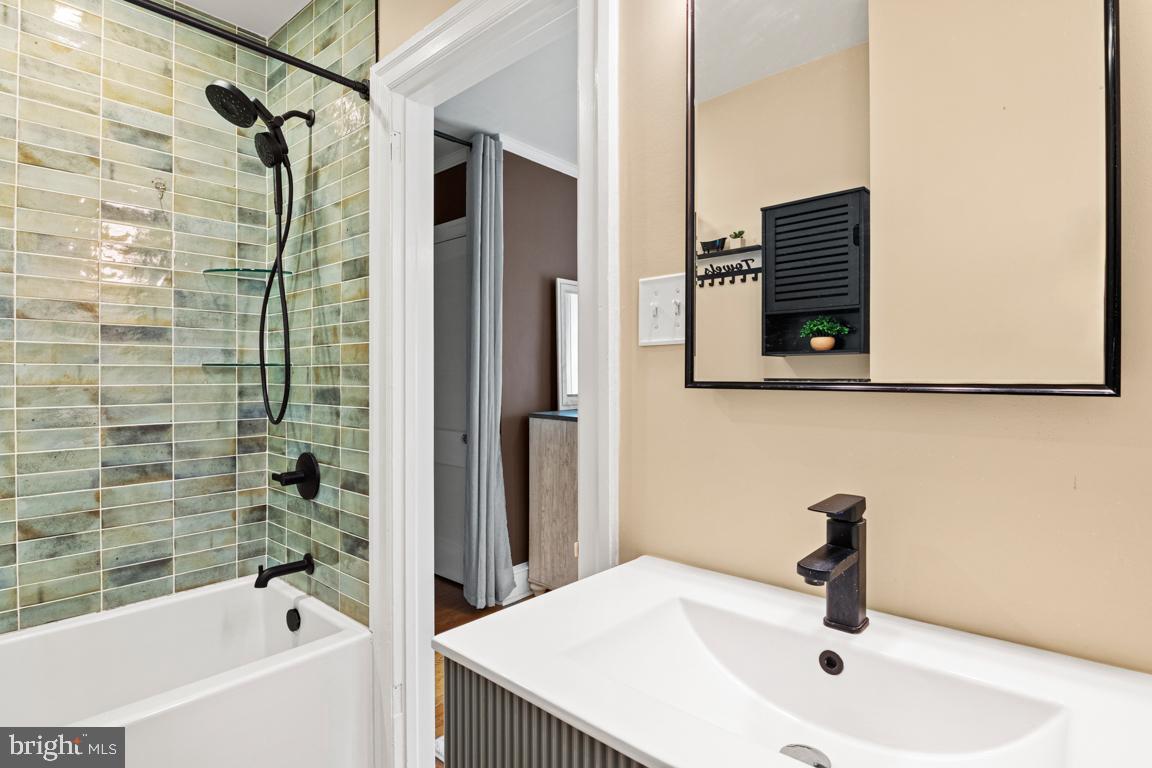 8023 Seminole Street Philadelphia, PA 19118 - Photo 24 of 42 a bathroom with a tub sink and mirror