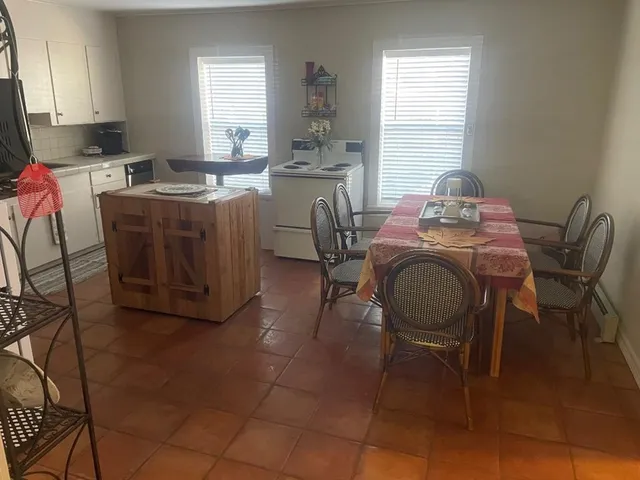 a dining room with furniture a window and kitchen view