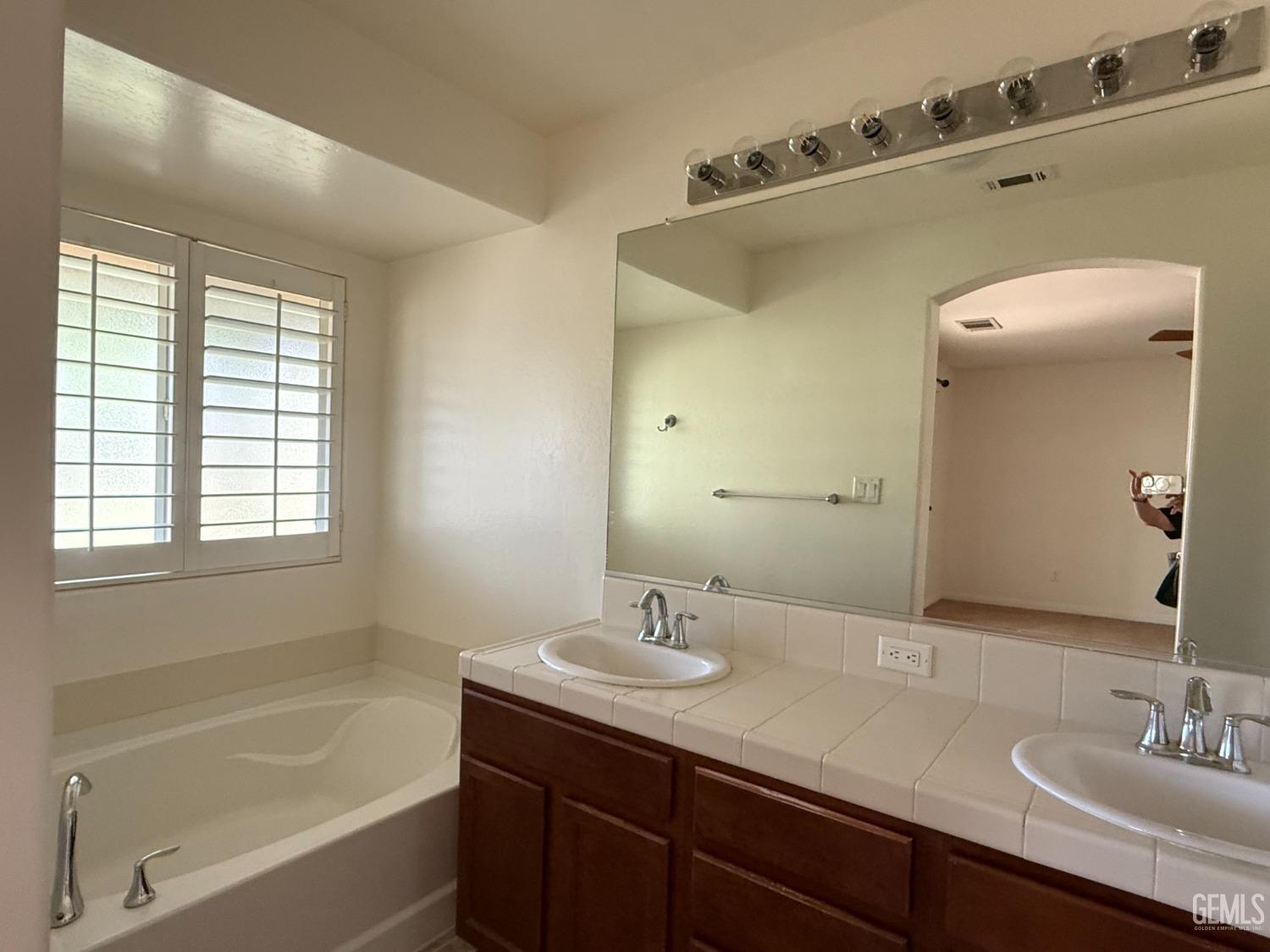 Undisclosed Address Bakersfield, CA 93311 - Photo 16 of 23 a bathroom with a tub sink and mirror