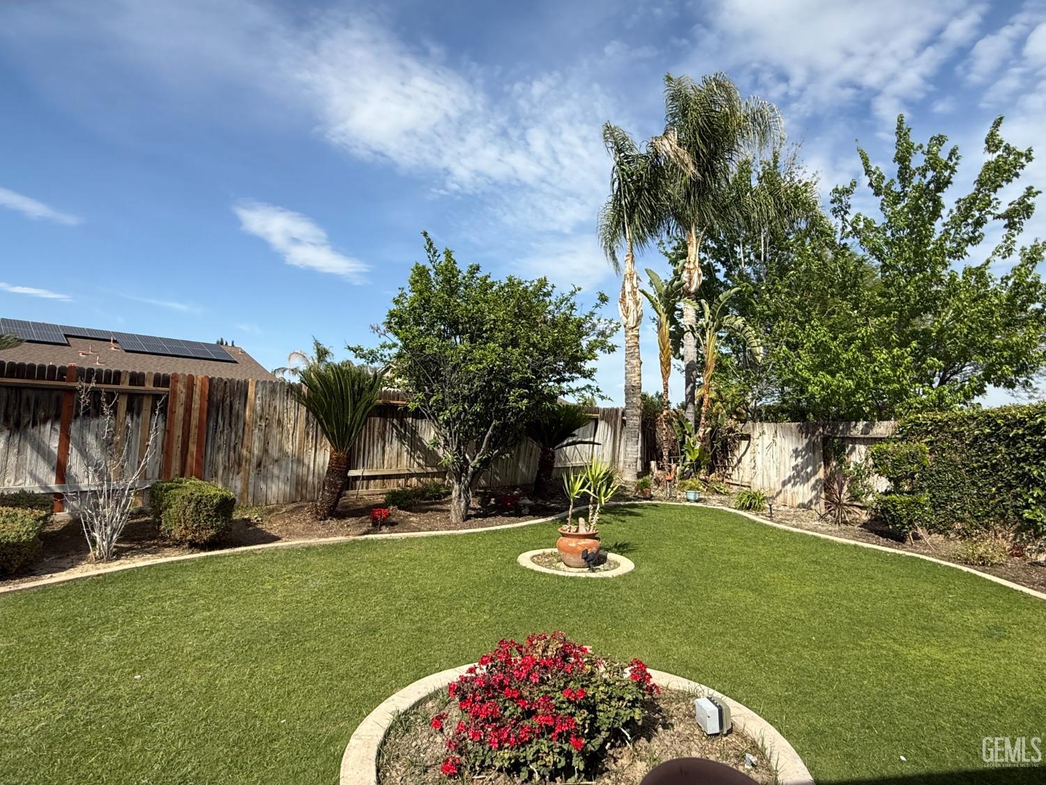 Undisclosed Address Bakersfield, CA 93311 - Photo 17 of 23 a view of a backyard with table and chairs and a garden