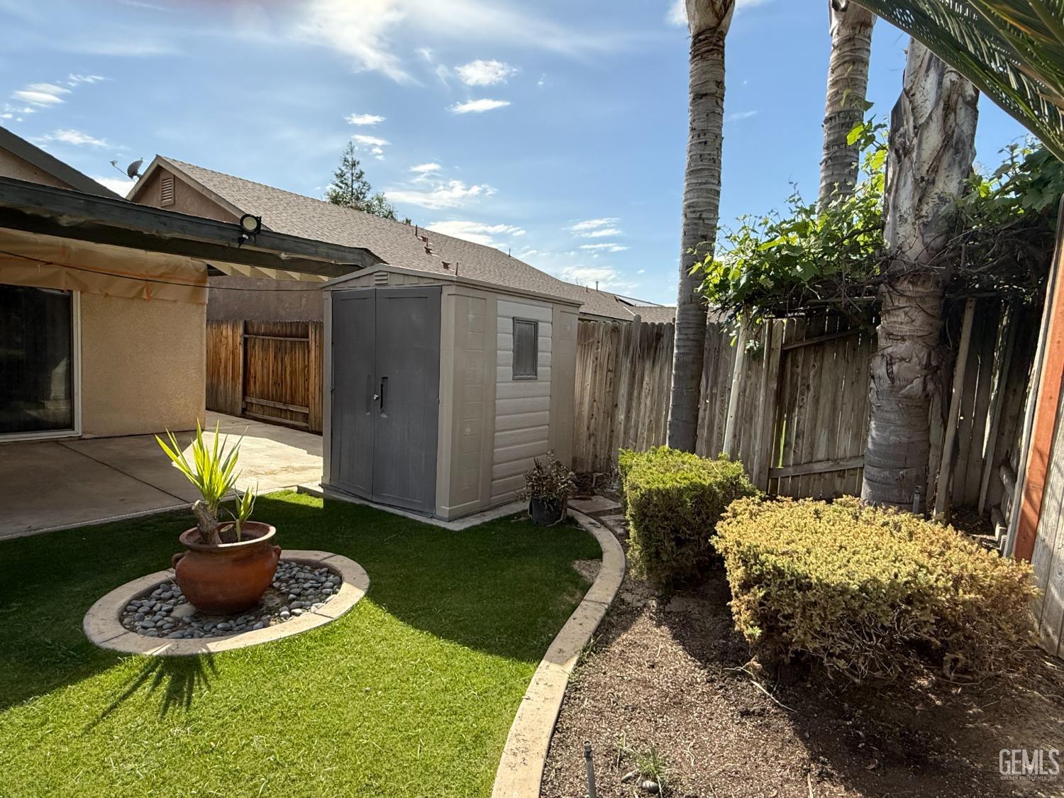 Undisclosed Address Bakersfield, CA 93311 - Photo 18 of 23 a backyard of a house with table and chairs with wooden fence