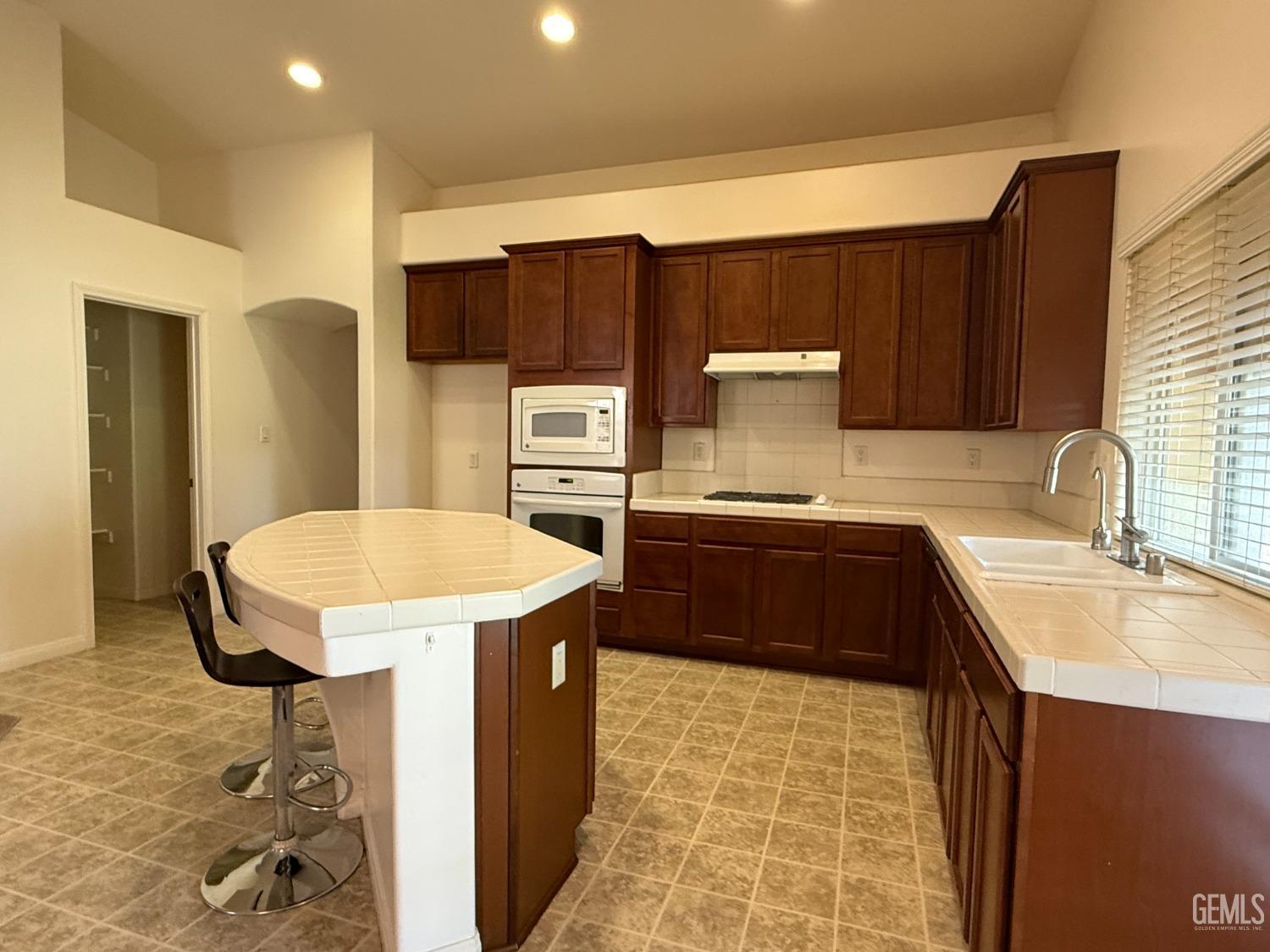 Undisclosed Address Bakersfield, CA 93311 - Photo 6 of 23 a kitchen with a sink a stove and a refrigerator
