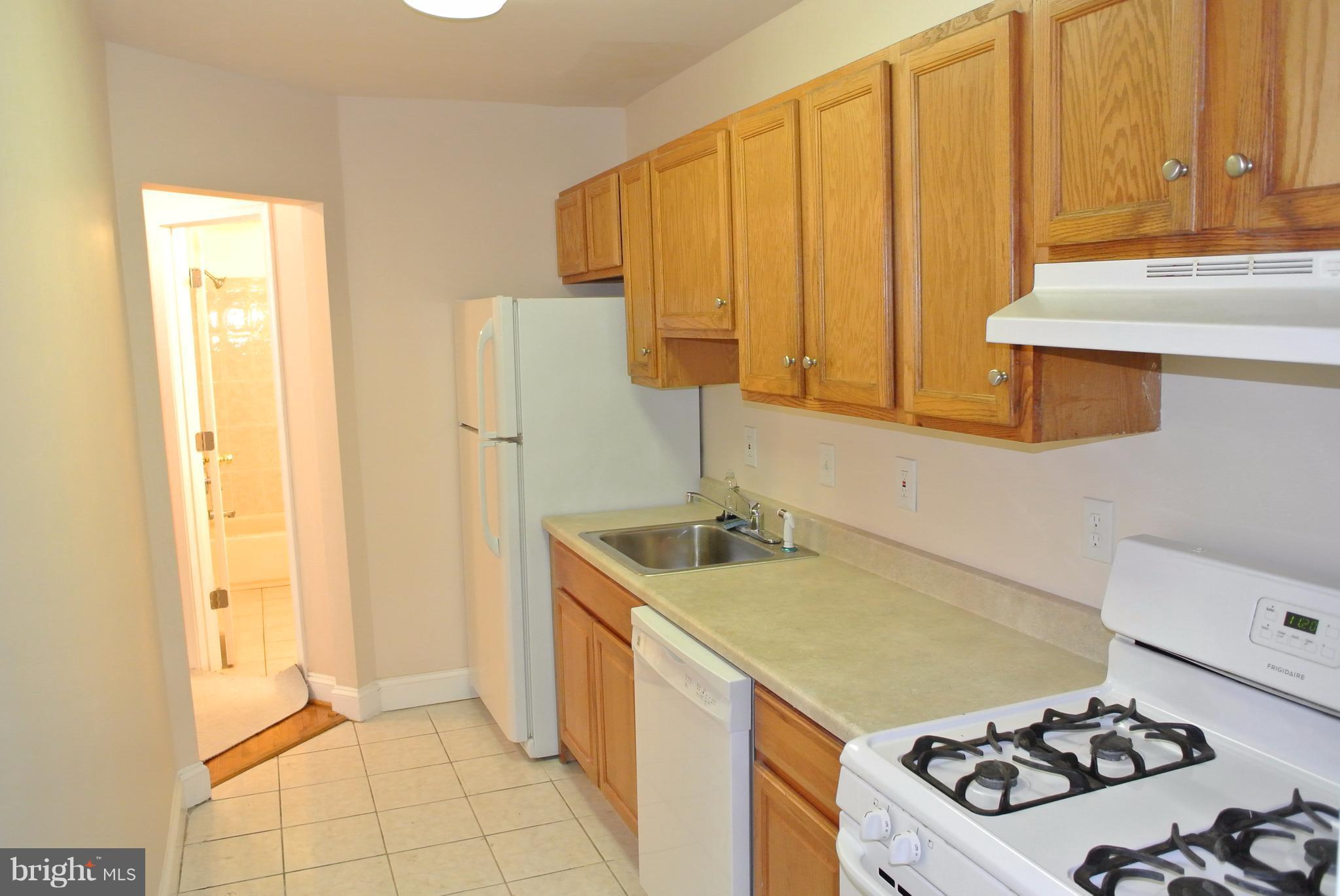 3216 28th Street Southeast, Unit 2 Washington, DC 20020 - Photo 3 of 17 a kitchen with a sink a stove and a refrigerator