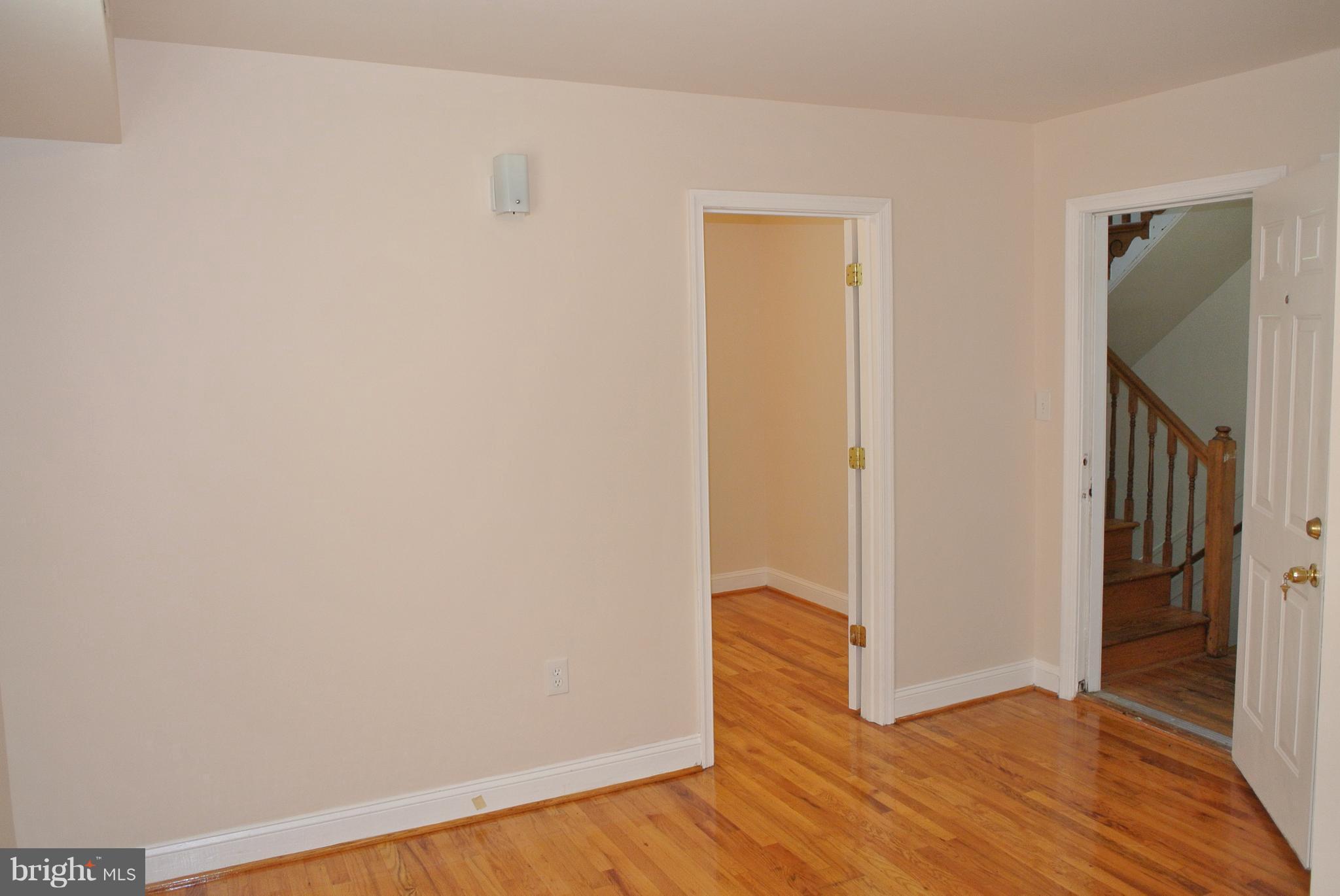 3216 28th Street Southeast, Unit 2 Washington, DC 20020 - Photo 4 of 17 a view of an empty room with wooden floor and a hallway