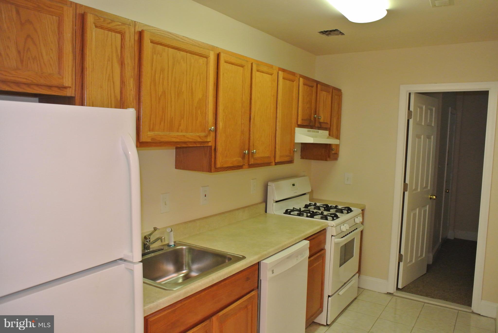 3216 28th Street Southeast, Unit 2 Washington, DC 20020 - Photo 7 of 17 a kitchen with a sink and a refrigerator