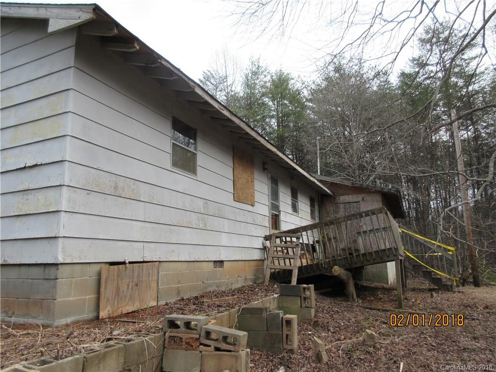 662 Mcguinn Road Mill Spring, NC 28756 - Photo 13 of 15 a backyard of a house with wooden deck and trees