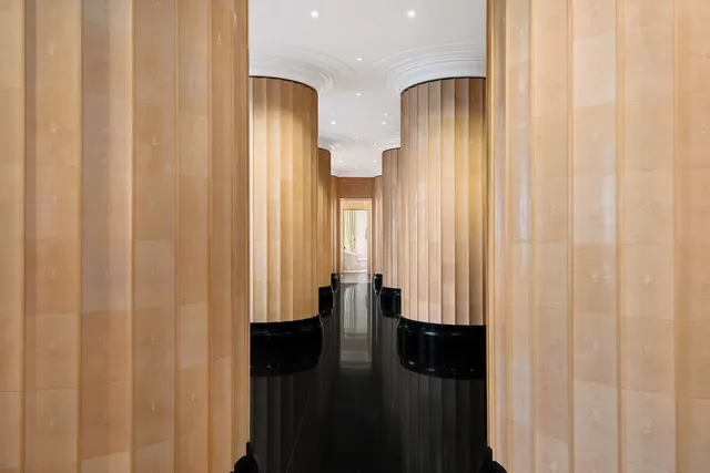 a spacious bedroom with a bed chandelier and a window