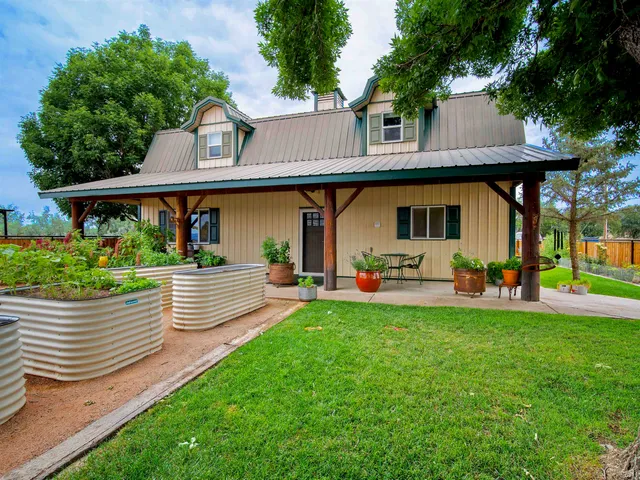a view of a patio with table and chairs potted plants and large tree