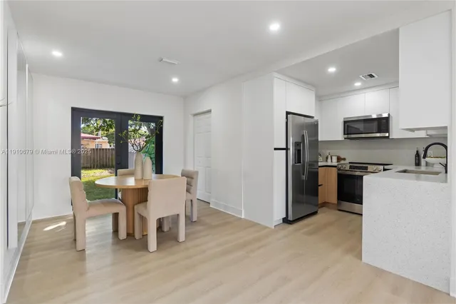 a kitchen with a table chairs refrigerator and microwave