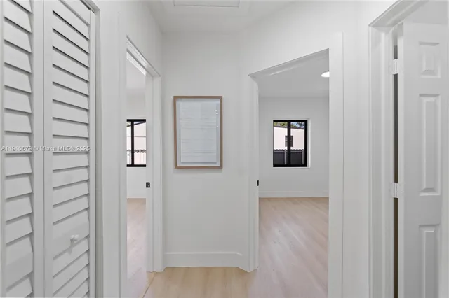 a view of a room with wooden floor and mirror
