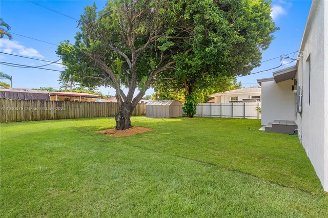 a view of a house with a tree in the grass