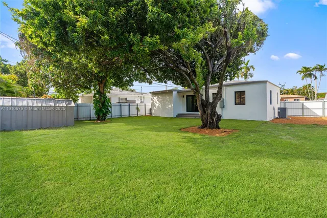 a white house that has a tree in front of it