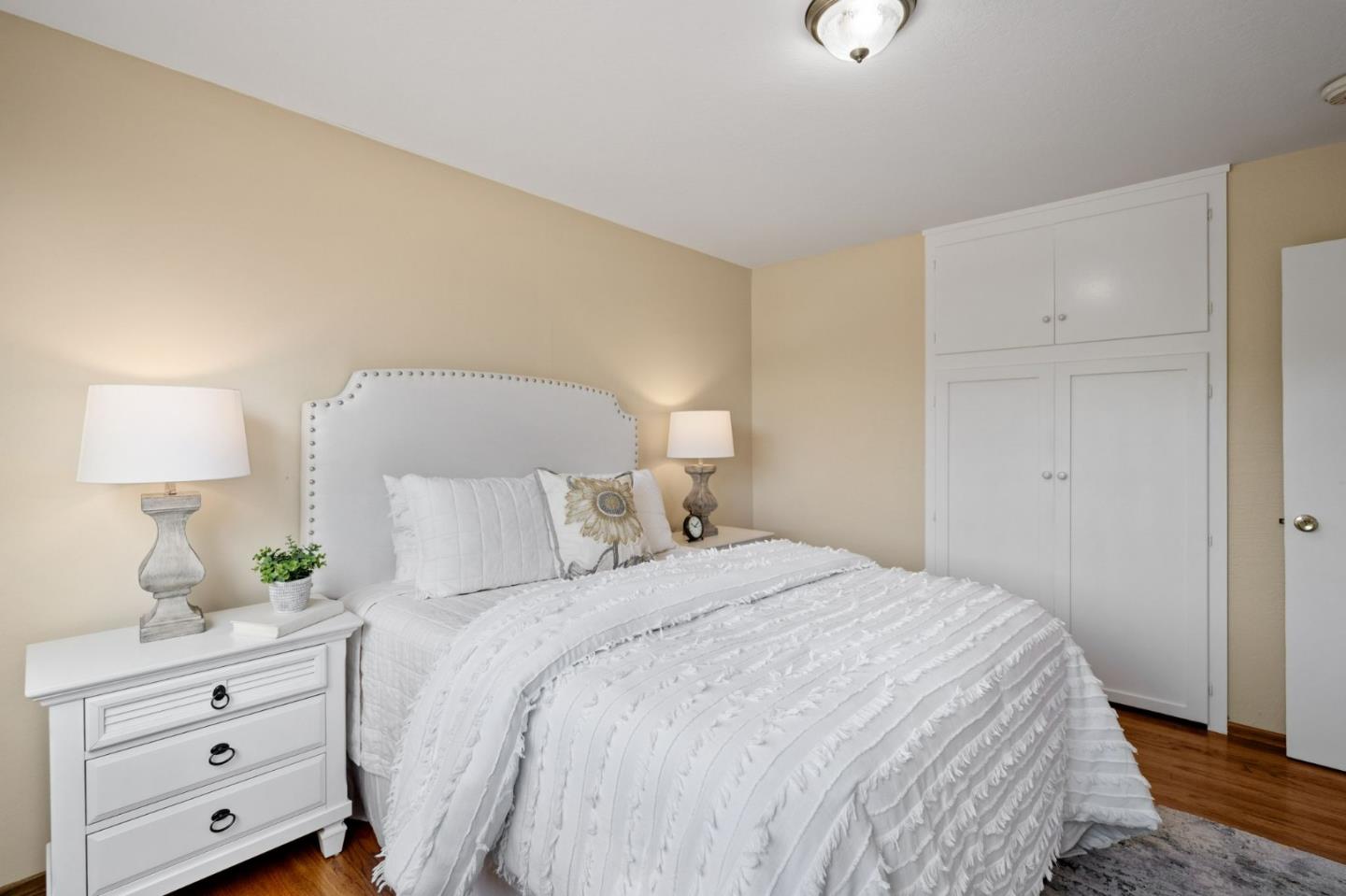 1127 Palou Drive Pacifica, CA 94044 - Photo 12 of 25 a bedroom with a bed and a lamp on dresser