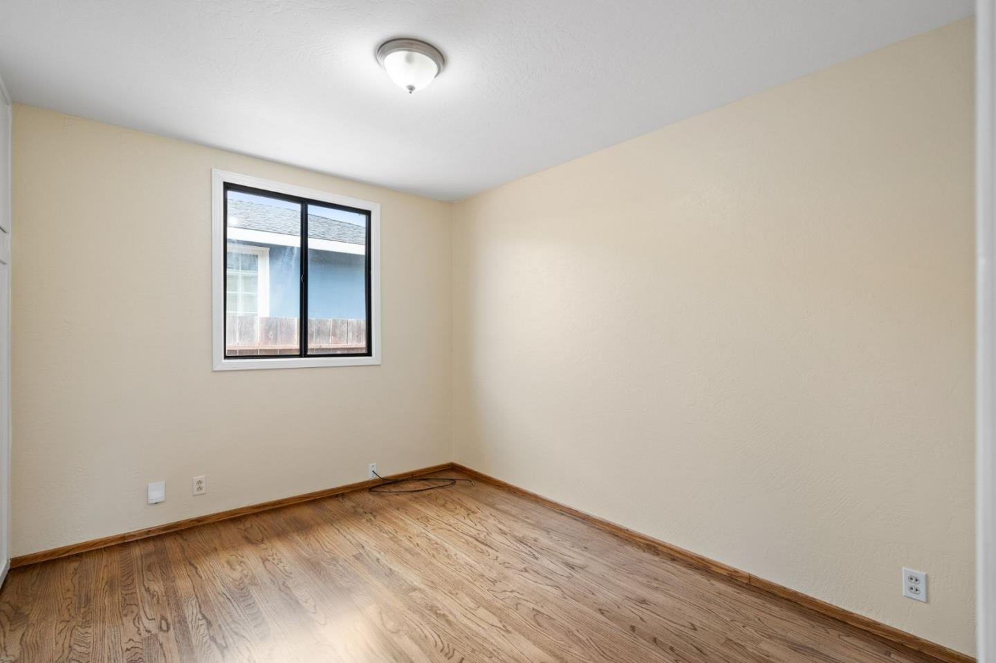 1127 Palou Drive Pacifica, CA 94044 - Photo 16 of 25 an empty room with wooden floor and windows