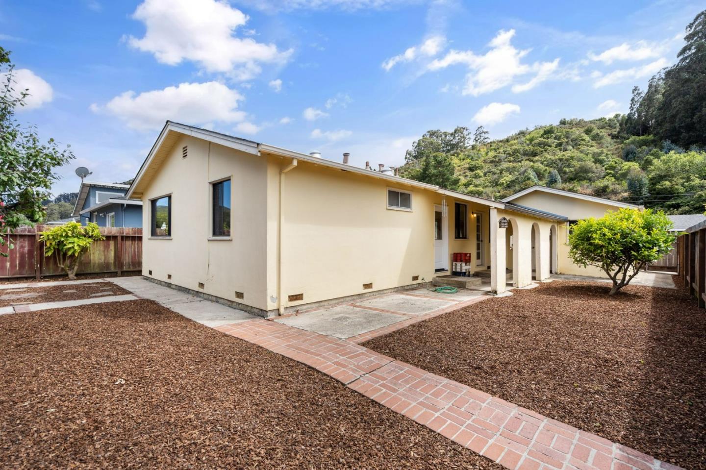 1127 Palou Drive Pacifica, CA 94044 - Photo 21 of 25 a front view of a house with a yard and garage