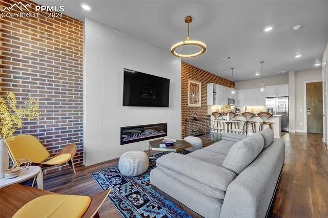 a living room with furniture wooden floor and a flat screen tv