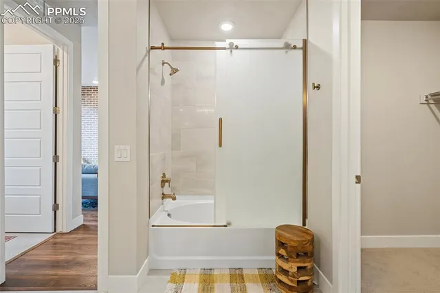 a bathroom with a double vanity sink a large mirror a shower and bathtub