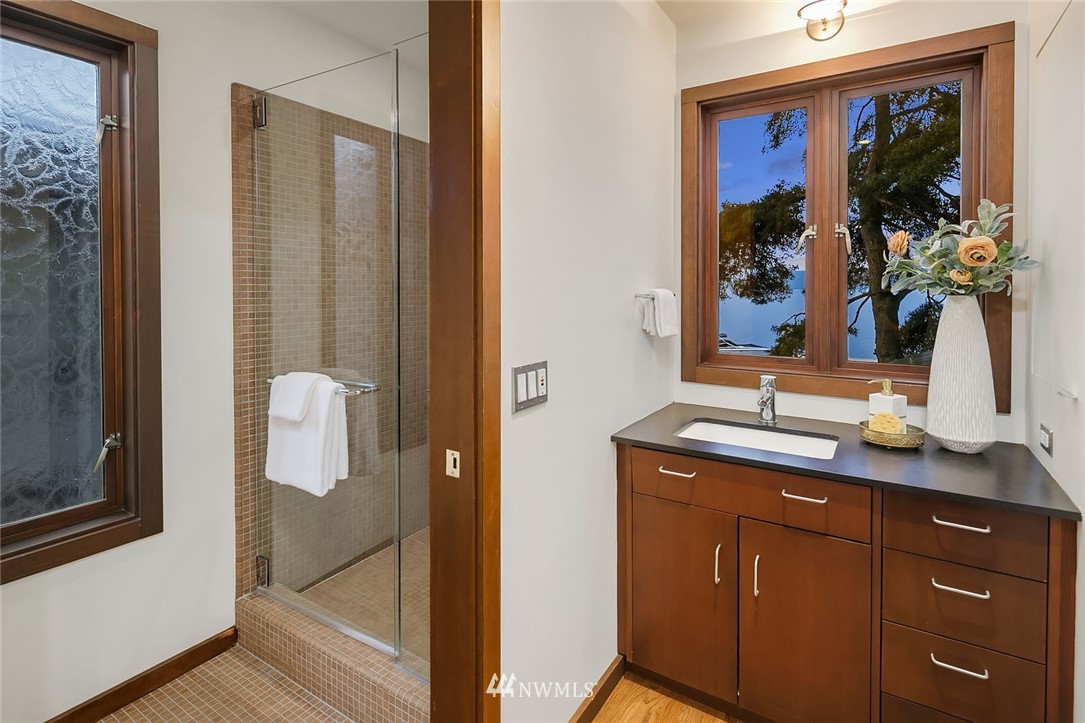 6669 Northeast Windermere Road Seattle, WA 98115 - Photo 18 of 36 a bathroom with a granite countertop sink a mirror and a shower