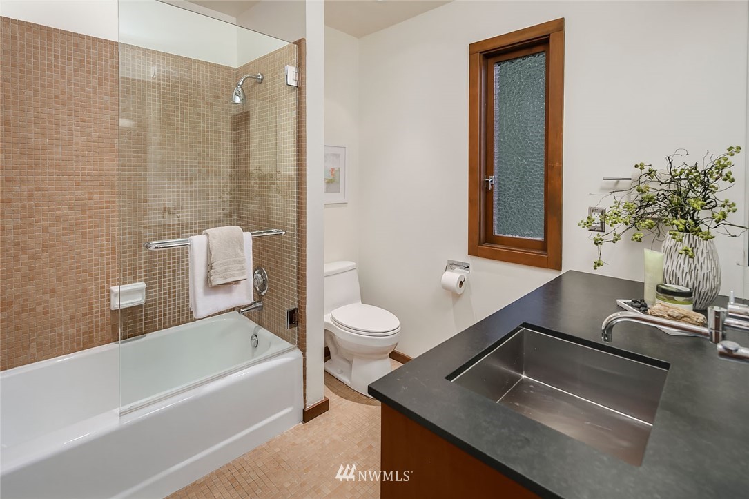6669 Northeast Windermere Road Seattle, WA 98115 - Photo 26 of 36 a bathroom with a tub a sink and a large mirror