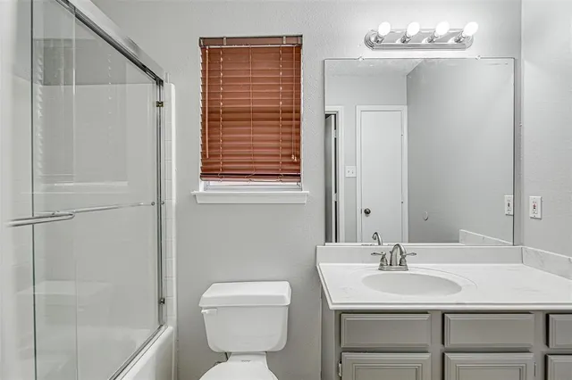 a white toilet sitting next to a shower
