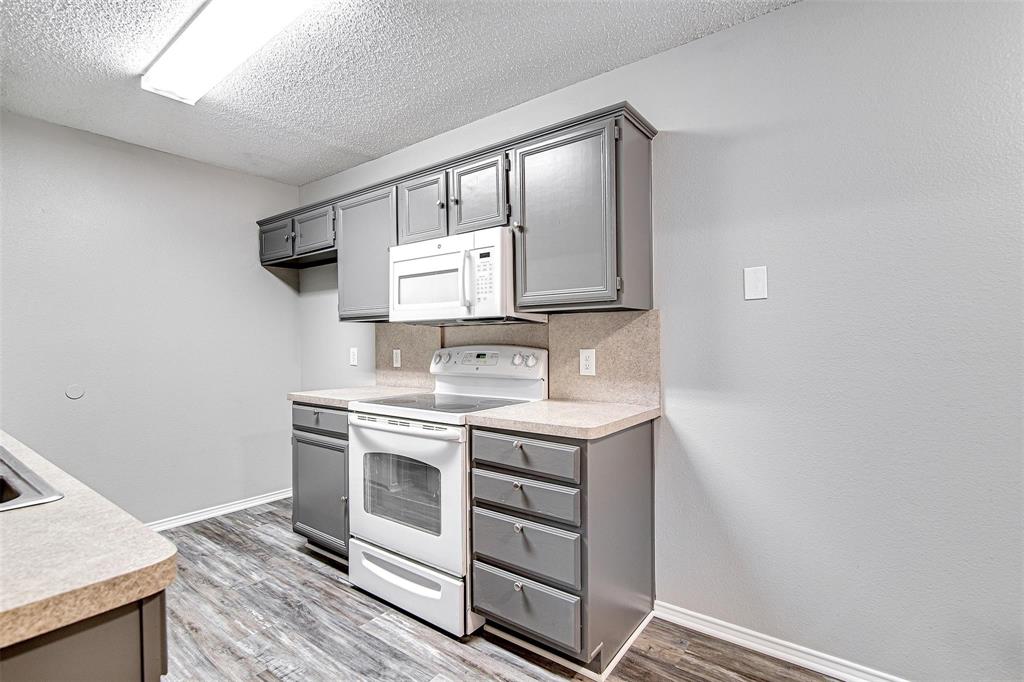 636 Green Mountain Road Burleson, TX 76028 - Photo 7 of 19 a view of cabinets a sink and a microwave in a room