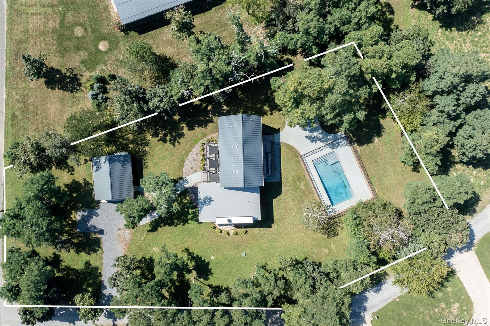 an aerial view of residential house with outdoor space and trees